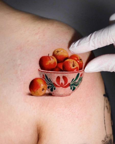 Tiny apple tattoo on the left inner arm.