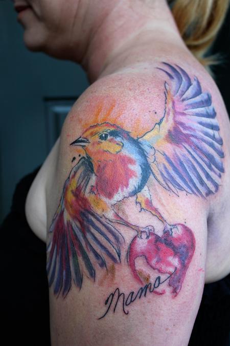 Realistic robin tattoo on the left inner forearm.