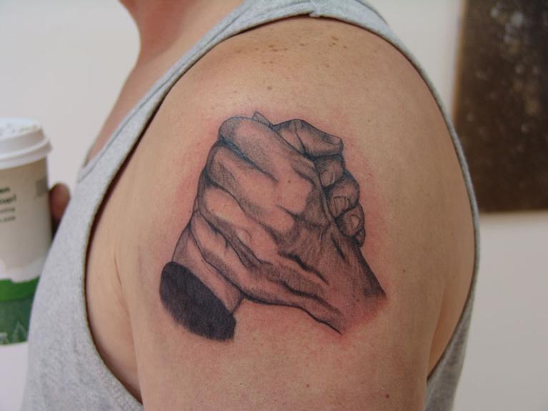 Holding hands matching tattoos for couple