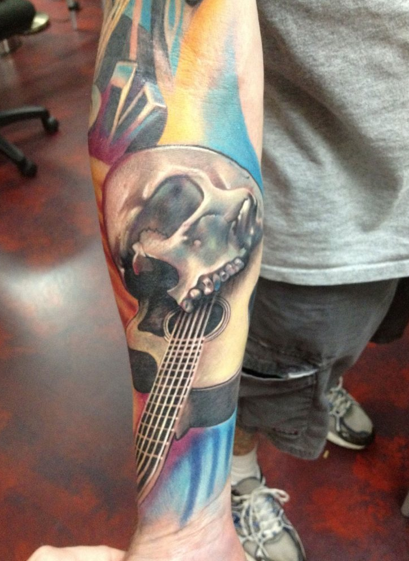 Tattoo of a musical sleeve with skull realistic guitar and old school  microphone Tattoo on the