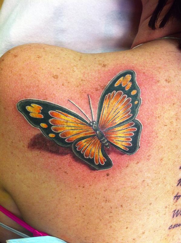 Blue And Black Butterfly Ink Tattooed On Upper Back