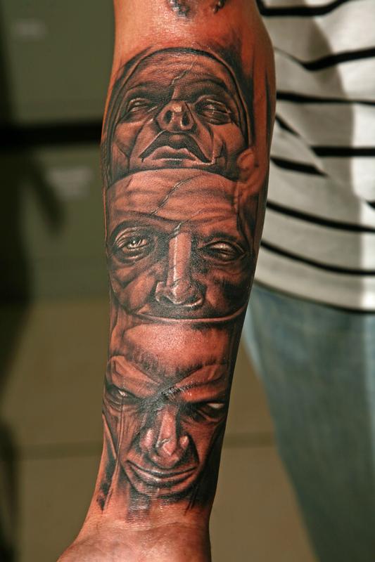 Sketch work faces tattooed on the bicep
