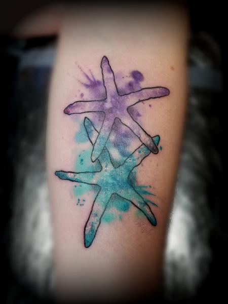 Little starfish tattoo located on the upper arm.