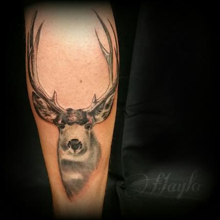 Fine line style deer head tattoo located on the tricep.