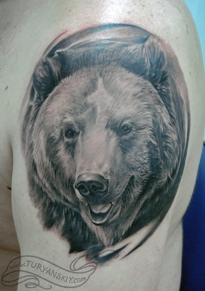 Black and grey bear tattoo on the right inner forearm.